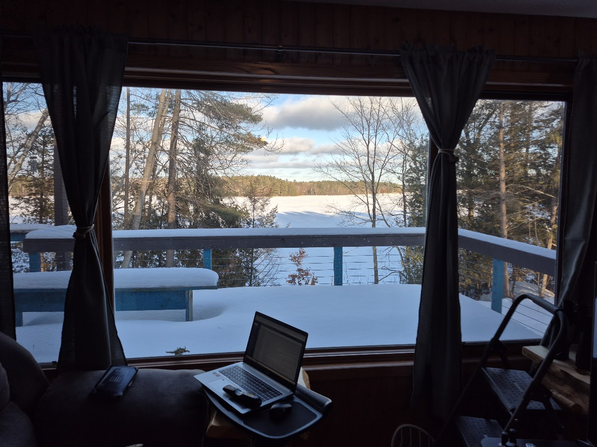 Laptop at Lake Krishyshire with a snowy lake view outside the window